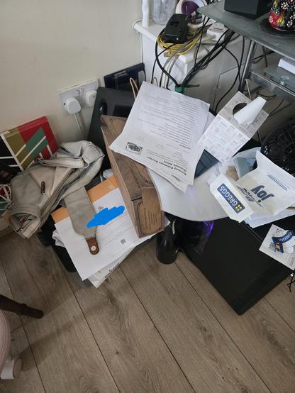 A messy pile of paperwork, printer living on the floor covered in said paperwork, just a big old pile of mess